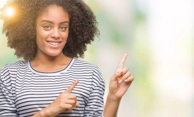 Genç afro Amerikalı kadın gülümseyerek ve iki elleri ve parmakları ile tarafına işaret kamera bakarak izole arka plan üzerinde.