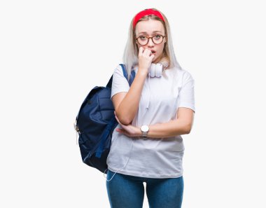 Gözlük ve sırt çantası stresli ve gergin elle çivi ısırma ağzına bakarak izole arka plan üzerinde giyen genç sarışın öğrenci kadın. Anksiyete sorunu.