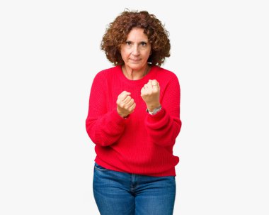 Güzel orta ager üst düzey kadın kırmızı kış kazak izole üzerinde arka plan yumruk savunma hareketi, kızgın ve üzgün yüz, sorunu korkuyor ile savaşmaya hazır