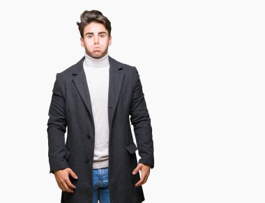 Komik surat ile yanakları şişirme izole arka plan üzerinde kış ceket giyen genç zarif adam. Ağız ile hava, deli ifade şişirilmiş.