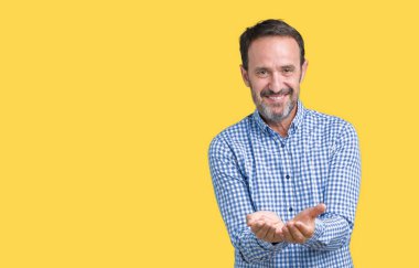 Yakışıklı orta yaş zarif üst düzey adam izole alma veya jest vererek birlikte el avuç içi ile gülen arka plan. Ayrı tutma ve koruma