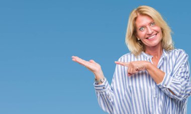 Orta yaş sarışın iş kadını üzerinden hayran ve el ile sunulması ve parmak ile işaret ederken kameraya gülümseyen izole arka plan.