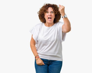 Öfkeli ve sinirli sinirli ve öfke ile bağırarak süre öfkeli yumruk yükselterek izole arka plan üzerinde beyaz t-shirt giyen güzel orta ager kadın kıdemli. Öfke ve agresif kavramı.
