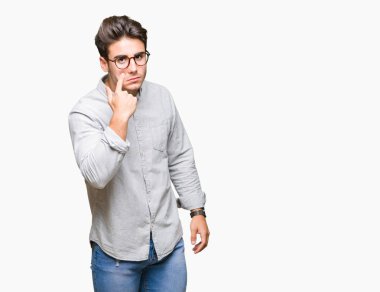Genç yakışıklı adam gözlük izole üzerinde arka plan işaret jest göz izlemek için şüpheli ifade