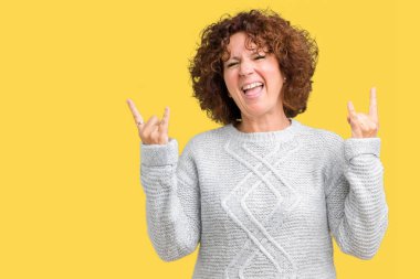 Deli ifade rock simge elle yapıyor ile bağırarak izole arka plan üzerinde kış kazak giyen güzel orta ager üst düzey kadın. Müzik yıldızı. Ağır kavramı.