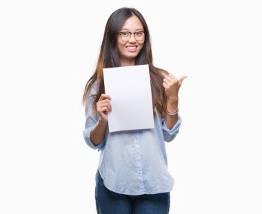İşaret ve başparmak kadar mutlu yüz gülümseyen tarafı ile gösteren izole arka plan üzerinde boş kağıt tutan Genç Asyalı kadın