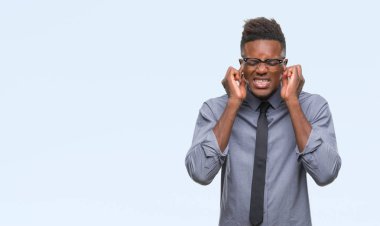 Yüksek sesle müzik gürültü rahatsız ifade parmaklarıyla kulaklarıyla kapsayan izole arka plan üzerinde genç Afro-Amerikalı iş adamı. Sağır kavramı.