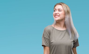 Genç Sarışın kadın uzak tarafına yüzünde, doğal ifade gülümseme ile seyir izole arka plan yüzünden. Kendine güvenen gülüyor.