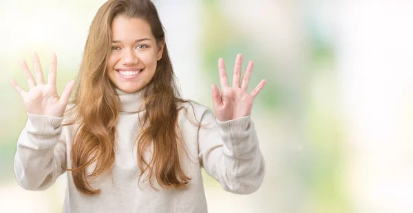 タートルネックのセーターを着ている若い美しいブルネットの女性分離で背景が表示され 自信を持って 幸せな笑みを浮かべている間 番号を指で上向き — ストック写真