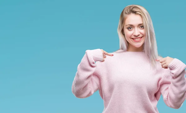年轻的金发女人穿着冬季毛衣在孤立的背景下 脸上露出自信的笑容 用手指自豪和快乐地指着自己 — 图库照片