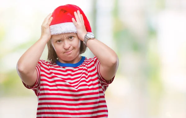 患有唐氏综合症的年轻成年妇女戴着圣诞帽在孤独的背景下患有头痛绝望和紧张 因为疼痛和偏头痛 手在头上 — 图库照片