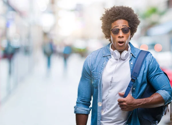 Hombre Afroamericano Usando Auriculares Mochila Sobre Fondo Aislado Asustado Shock —  Fotos de Stock