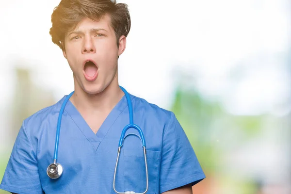 Unga Läkare Bär Medicinsk Uniform Över Isolerade Bakgrund Chock Ansikte — Stockfoto
