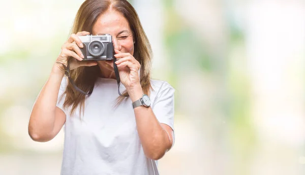 中年西班牙妇女拍照使用老式的照片相机在孤立的背景与一个快乐的脸站着 面带微笑 自信的微笑显示牙齿 — 图库照片