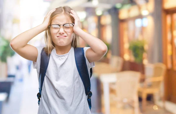 Young beautiful smart student girl wearing backpack over isolated background suffering from headache desperate and stressed because pain and migraine. Hands on head.