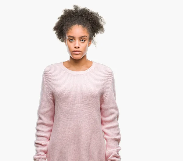 若いアフロのアメリカ人の女性の顔に真剣な表情で孤立した背景に冬のセーターを着ています シンプルで自然なカメラを見てください — ストック写真