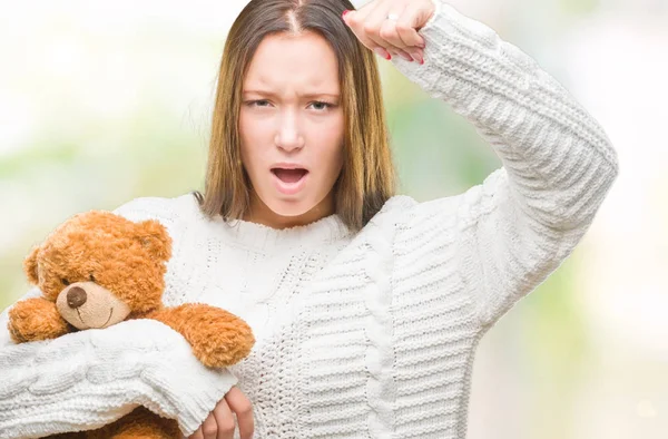 Joven Mujer Caucásica Sosteniendo Osito Peluche Sobre Fondo Aislado Molesto —  Fotos de Stock