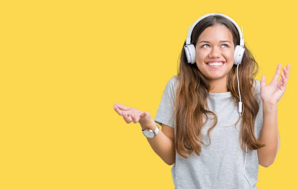 Νεαρή Όμορφη Γυναίκα Φορώντας Ακουστικά Ακούτε Μουσική Μέσω Απομονωμένη Φόντο — Φωτογραφία Αρχείου