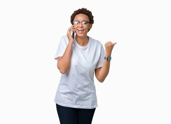年轻的非洲裔美国妇女在电话里交谈在孤立的背景指向和显示与幸福的脸微笑的一侧与拇指 — 图库照片