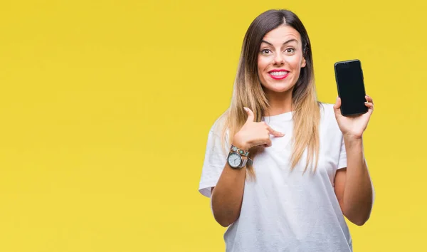 Young beautiful woman showing blank screen of smartphone over isolated background with surprise face pointing finger to himself