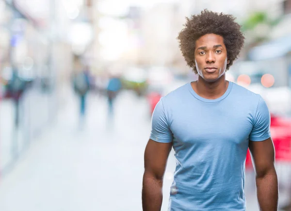 Afro american man over isolated background with serious expression on face. Simple and natural looking at the camera.