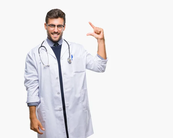年轻英俊的医生男子在孤立的背景微笑和自信的手势与手做大小标志与手指 而看和相机 测量概念 — 图库照片
