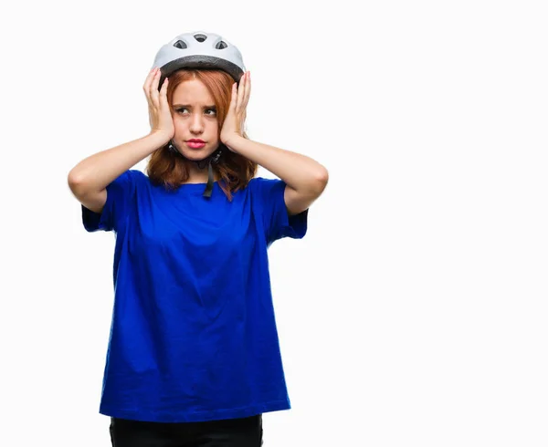年轻漂亮的女人穿着自行车头盔在孤立的背景下患有头痛绝望和压力 因为疼痛和偏头痛 手在头上 — 图库照片
