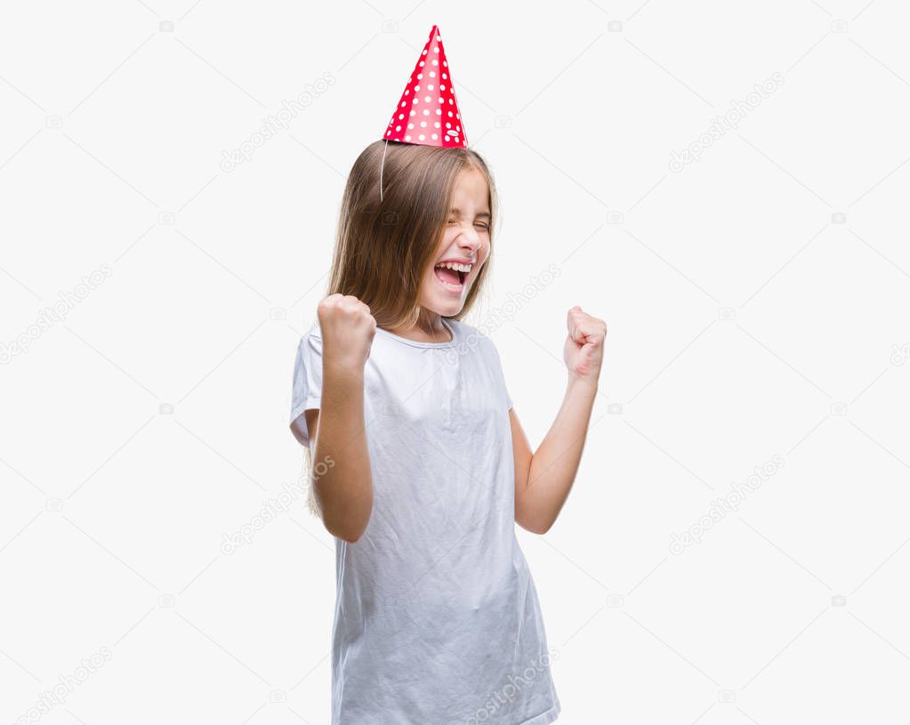 Young beautiful girl wearing birthday cap over isolated background very happy and excited doing winner gesture with arms raised, smiling and screaming for success. Celebration concept.