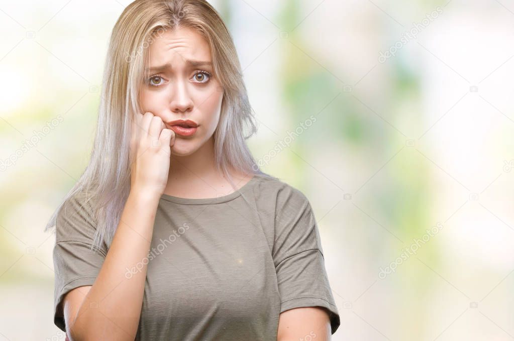 Young blonde woman over isolated background looking stressed and nervous with hands on mouth biting nails. Anxiety problem.