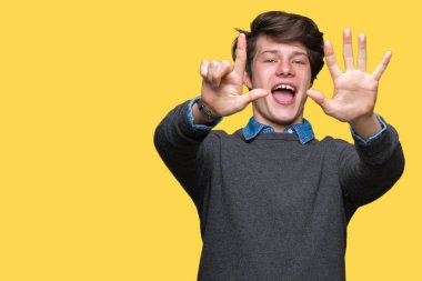 Genç yakışıklı zarif adam gösterilen ve parmakları ile işaret izole arka plan üzerinde kendinden emin ve mutlu gülümseyerek süre yedi numara.