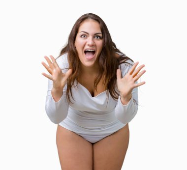 Artı boyutu genç overwight kadın güzel üzerinde beyaz iç çamaşırı giyiyor arka plan kutluyor deli izole ve silah ile başarı için yükseltilmiş ve açık gözleri heyecanlı çığlık hayrete düşürdü. Kazanan kavramı