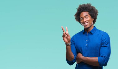 Mutlu yüz zafer işareti yaparken kameraya göz kırpıyor ile gülümseyen izole arka plan üzerinde Afro Amerikalı adam. İki numaralı.