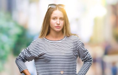 Güneş gözlüğü izole arka plan üzerinde giyen genç güzel sarışın kadın depresif ve kızgın ve korkmuş ağlıyor sıkıntı için endişeleniyorum. Üzgün ifade.