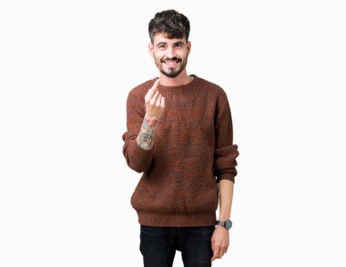 Genç yakışıklı adam giyen kış kazak Beckoning gel burada mutlu ve gülümseyerek el davet ile jest izole arka plan üzerinde