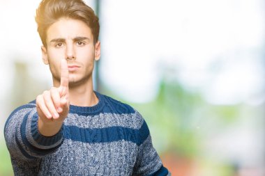 İzole genç yakışıklı adam arka plan işaret parmağını ve kızgın ifade ile