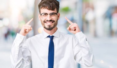 Hem el parmak, harika bir fikir ya da düşünce, iyi bellek ile baş gösteren gülümseyen genç yakışıklı iş adam gözlük izole üzerinde arka plan