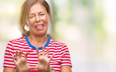 Orta yaş izole arka plan üzerine İspanyol kadın kıdemli tiksinti ifadesi, memnun ve korkulu tiksinti yüz yapıyorsun çünkü nefret tepki. Elleriyle kaldırdı. Sinir bozucu kavramı.