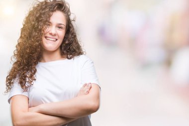 Güzel esmer kıvırcık saçlı Genç kız ile izole arka plan mutlu yüz gülümseyen üzerinde rahat t-shirt giyen silah kameraya bakarak geçti. Olumlu bir kişi.