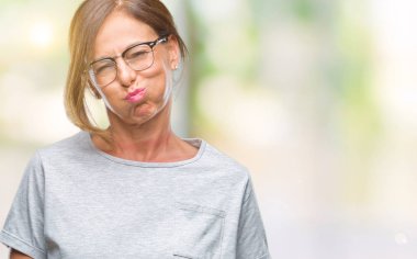 Komik surat ile yanakları şişirme izole arka plan üzerinde gözlük takan orta yaş İspanyol kadın kıdemli. Ağız ile hava, deli ifade şişirilmiş.