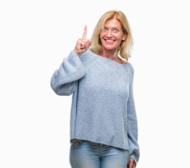 Orta yaş sarışın kadın başarılı fikirle izole arka plan işaret parmağı üzerinde kış kazak giyiyor. Çıktıktan ve mutlu. Bir numara.