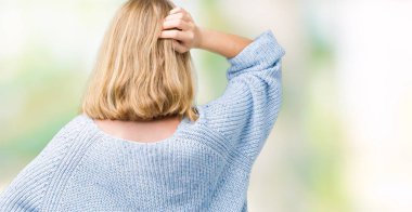 İzole arka plan geriye düşünme hakkında şüphe ile baş taraftan üzerinde mavi kazak giyen güzel genç kadın