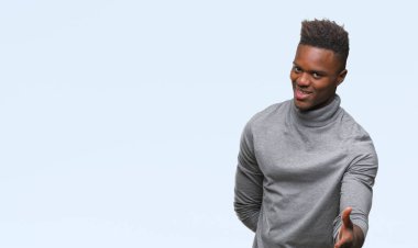 Afrikalı-Amerikalı genç dostu sunan el sıkışma tebrik ve davet edici olarak gülümseyen izole arka plan üzerinde. Başarılı iş.