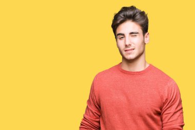 Genç yakışıklı adam seksi bir ifadeyle, neşeli ve mutlu yüzünü kameraya bakarak göz kırpıyor izole arka plan üzerinde.