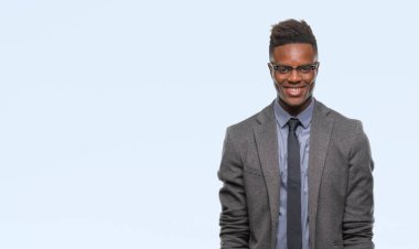 Yüzünde mutlu ve güzel bir gülümseme ile izole arka plan üzerinde genç Afro-Amerikalı iş adamı. Şanslı kişi.