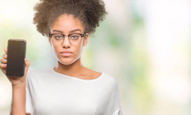 Genç güzel afro Amerikan gösteren smartphone ekran acımak yüz ciddi düşünüyorum üstünde kendine güvenen bir ifade ile izole arka plan üzerinde