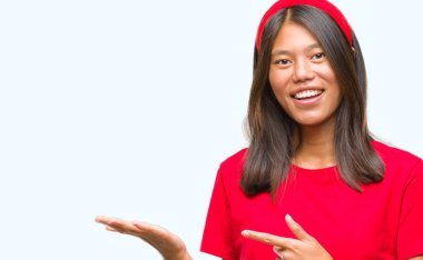 Genç Asyalı kadın üzerinden hayran ve el ile sunulması ve parmak ile işaret ederken kameraya gülümseyen izole arka plan.