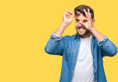 Yakışıklı delikanlı gülümseyen, parmakları ile mutlu yüz üzerinden seyir göz el ile ok jest yapıyor izole arka plan üzerinde güneş gözlüğü takıyor.