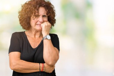 Güzel orta ager üst düzey kadın yüzünden stresli ve gergin elle çivi ısırma ağzına bakarak izole arka plan. Anksiyete sorunu.