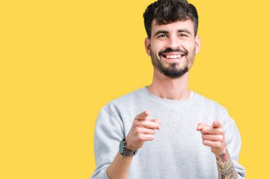 Fotoğraf makinesi ile mutlu ve komik yüz için parmakları işaret izole arka plan üzerinde sweatshirt giyen genç yakışıklı adam. İyi enerji ve vibes.