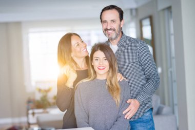 Güzel aile birlikte. Anne, baba ve kızı gülümseyen ve evde sevgi ile sarılma.